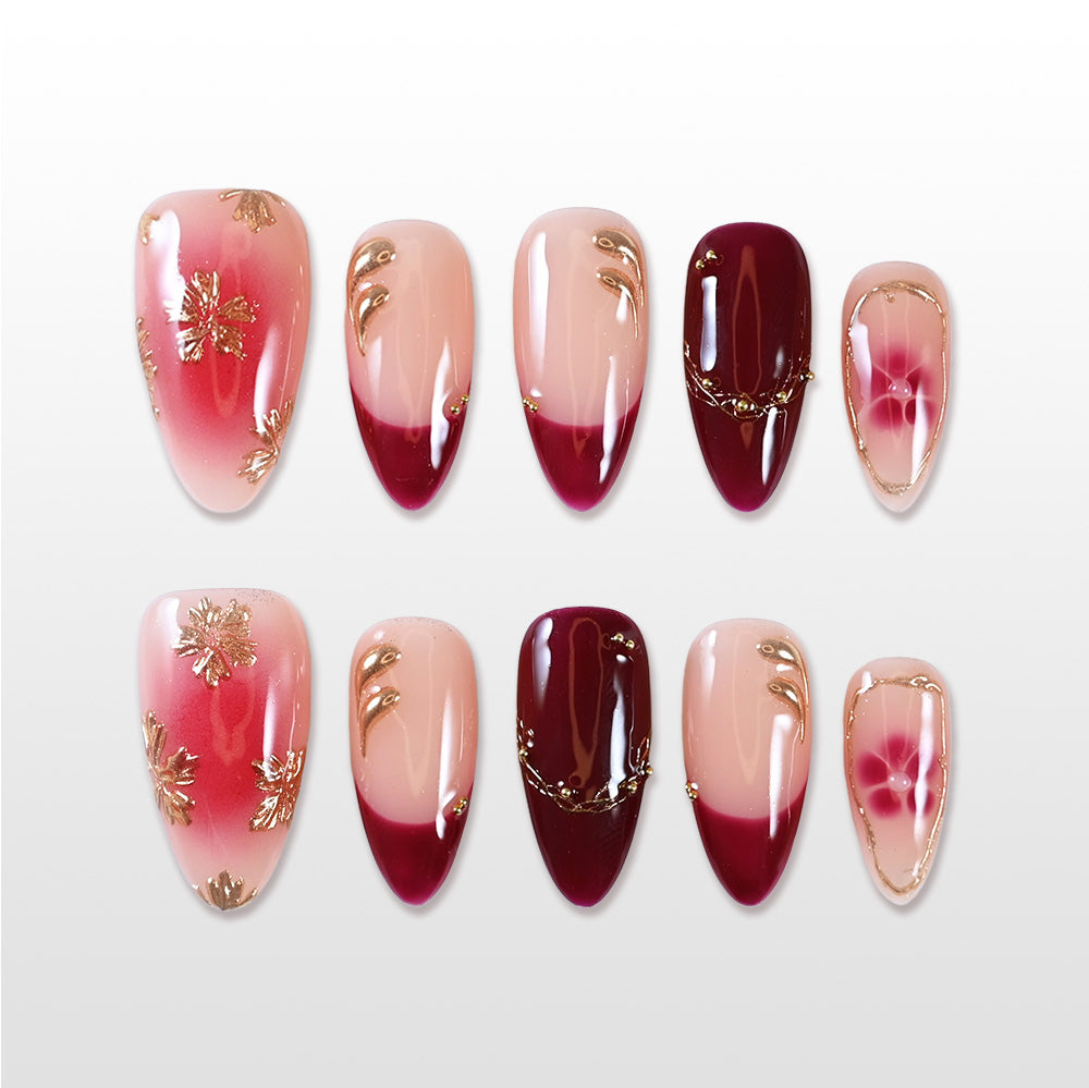 Handmade red and nude press on nails with gold floral accents and gradient design