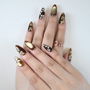 Charmeenail luxury acrylic nails in black and metallic gold with hand-painted blossoms