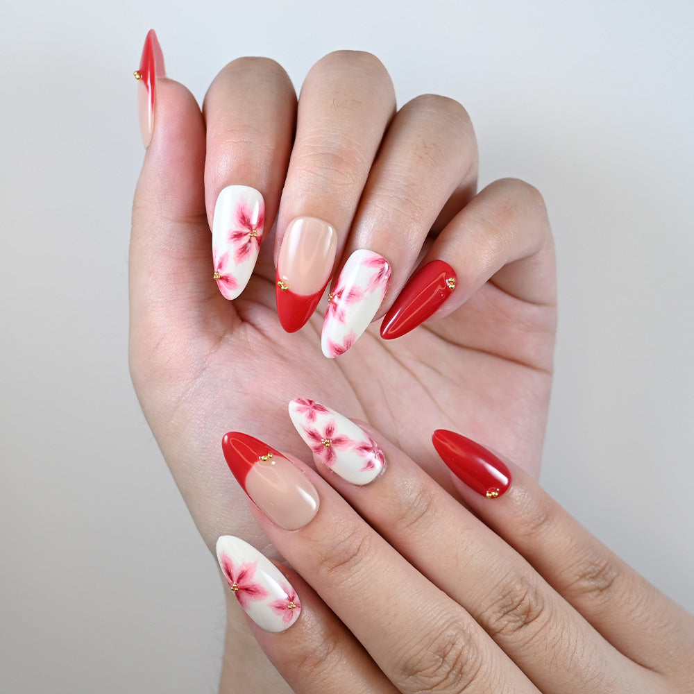 Medium almond reusable press-on nails with red tips and flower art details