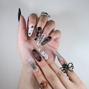 Long almond reusable press-on nails with spooky skulls, webs, and gothic silver accents