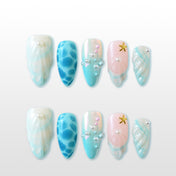 Ocean-inspired press-on nails with seashell texture, pearls, and starfish charm
