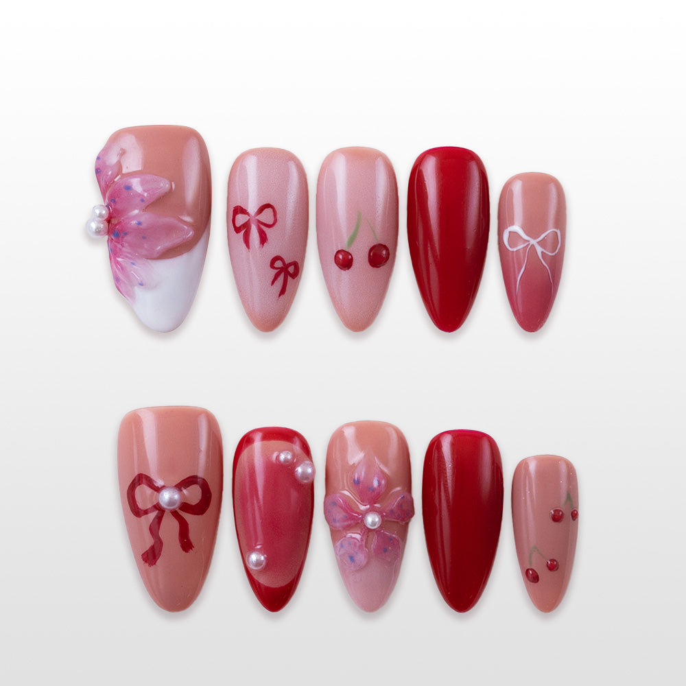 Cherry and bow design press-on nails in red and pink tones