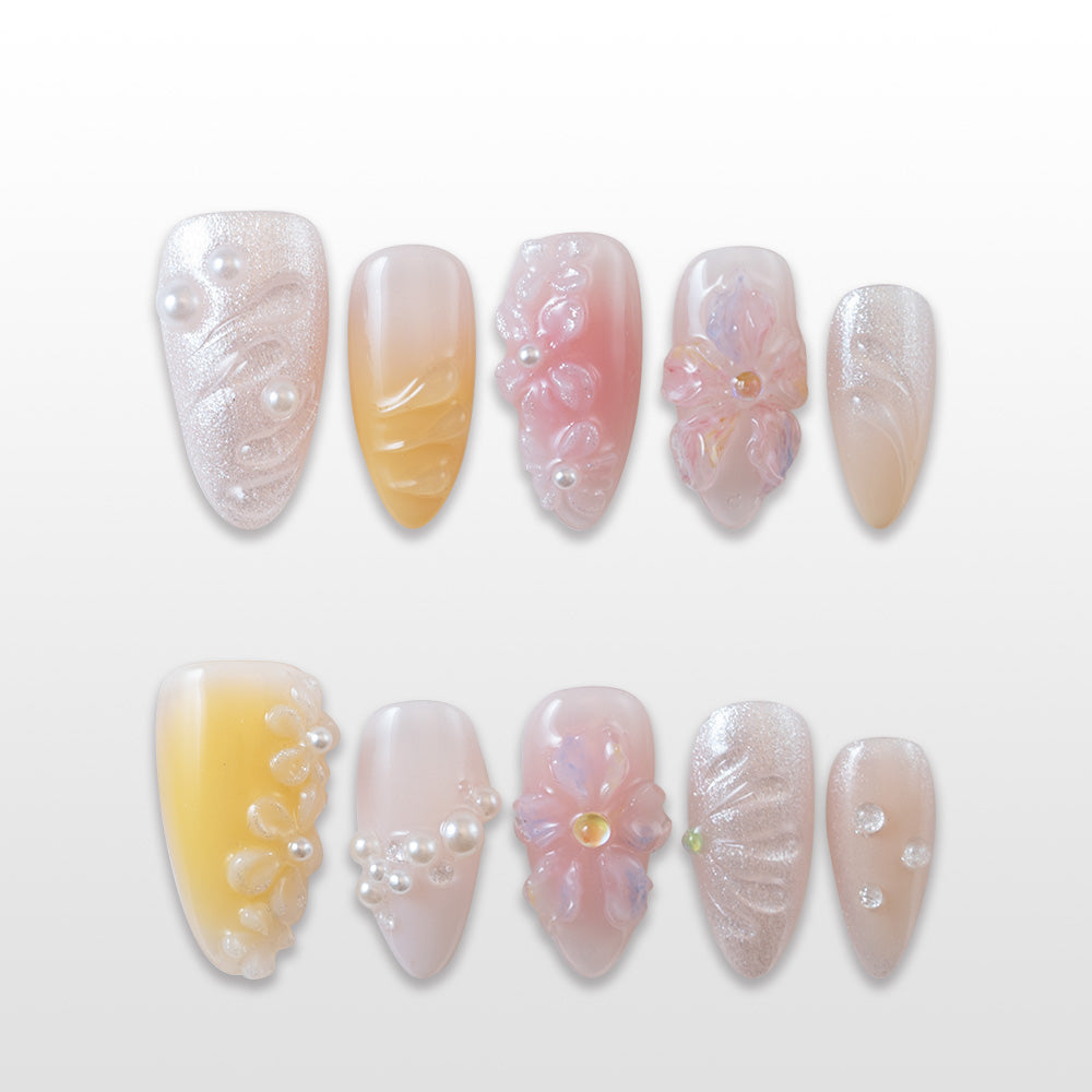 Yellow and pink ombre press-on nails with 3D floral designs and pearl accents