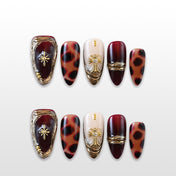 Luxury almond press-on nails featuring animal print and gold cross embellishments