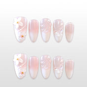 Pink and white ombre press-on nails with 3D flowers, pearls, and butterfly details