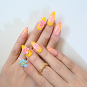 Bright and playful press-on nails with pink flowers, pearls, and colorful accents