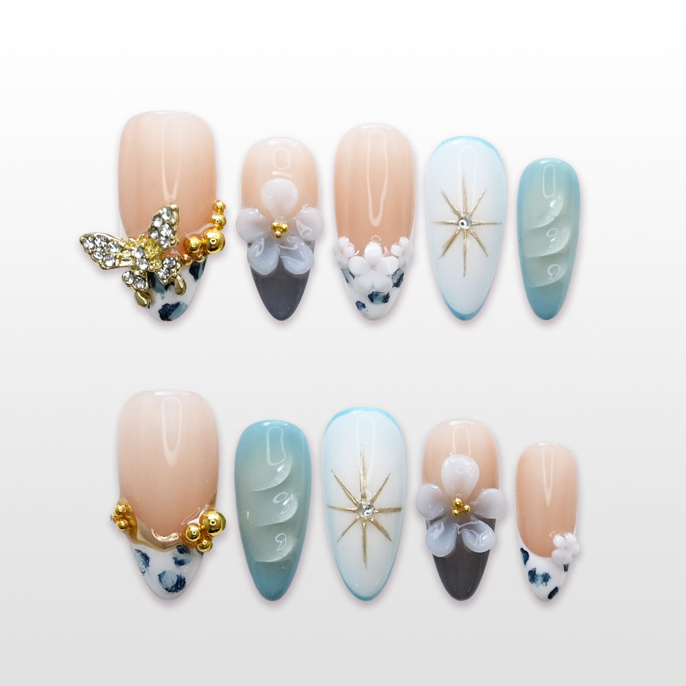 Elegant press-on nails with blue-green gradient, crystal butterfly charm, and 3D floral accents