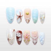 Beach-inspired press-on nails with 3D starfish, seashell, and pearl accents