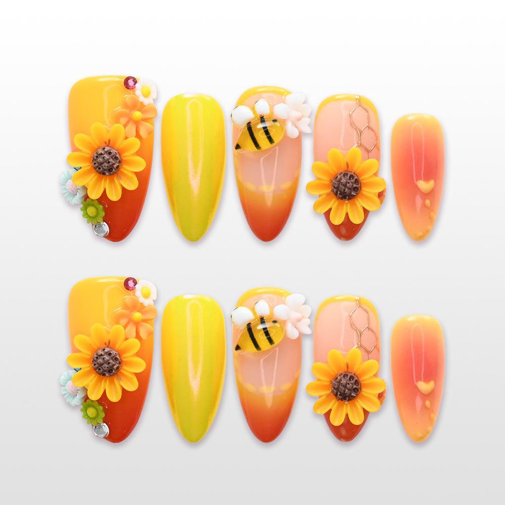 Bright sunflower press-on nails with 3D bee design, honeycomb details, and ombre yellow-orange tips
