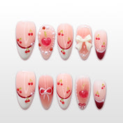 Cute pink press-on nails with cherry design, 3D bow, and pearl accents