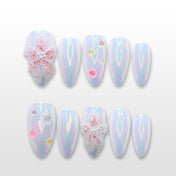 Iridescent press-on nails with 3D pink flower, pearl accents, and holographic shine