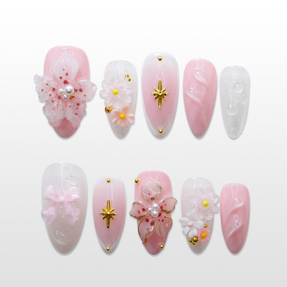Pink press-on nails with 3D floral designs, pearl accents, and gold star embellishments
