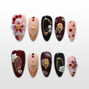 Vintage press-on nails with black, wine red, and nude tones featuring 3D flowers and gold accents