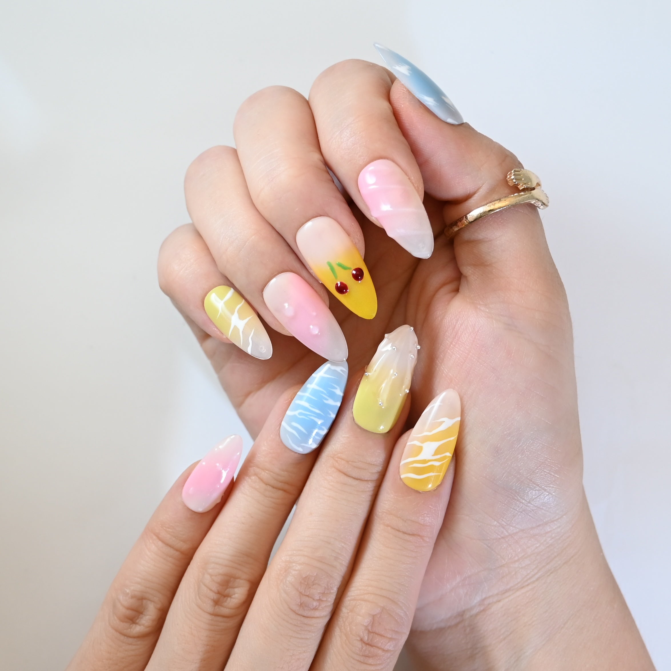 Summer fruit press-on nails with pink and yellow gradient, cherries, and pearl details