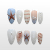 Beach-themed press-on nails with 3D starfish, seashell accents, and pearl details