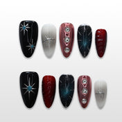 Black and red press-on nails with silver starburst, chrome accents, and galaxy glitter design
