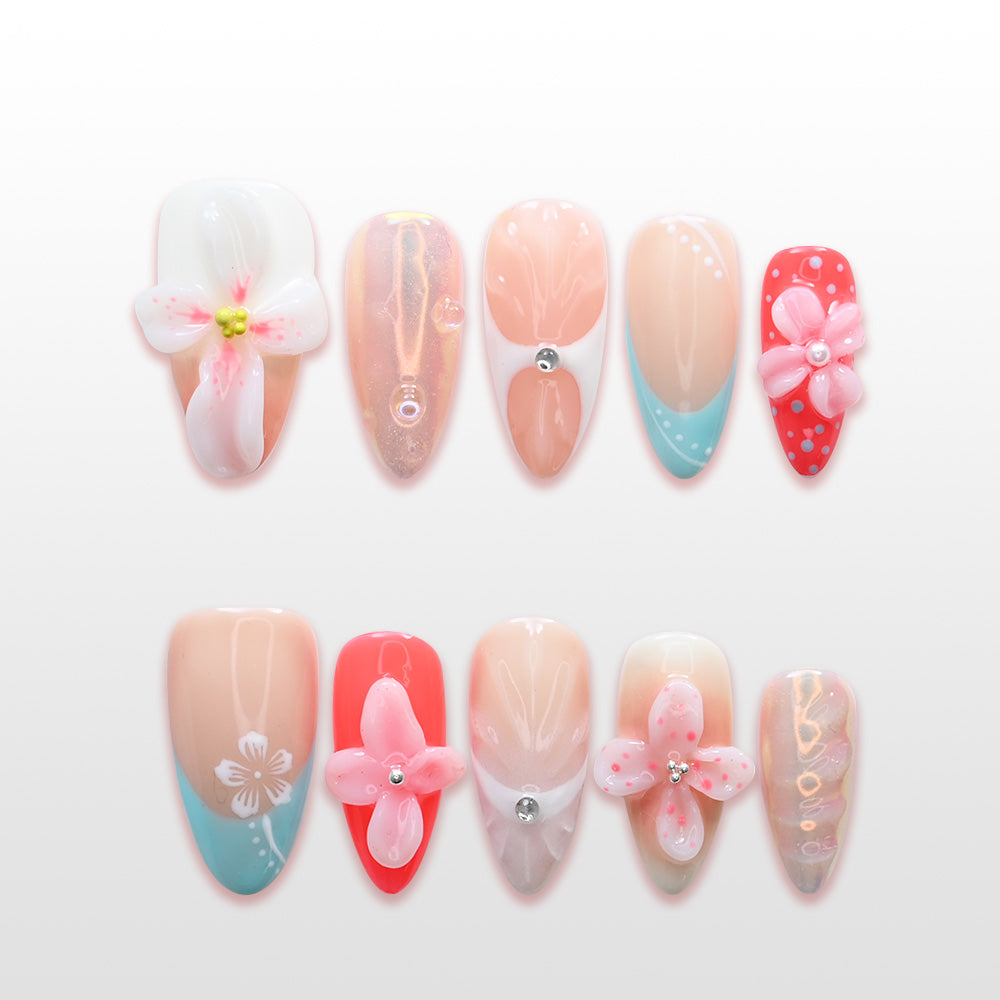 Pink and coral press-on nails with 3D flower design, turquoise French tips, and rhinestones