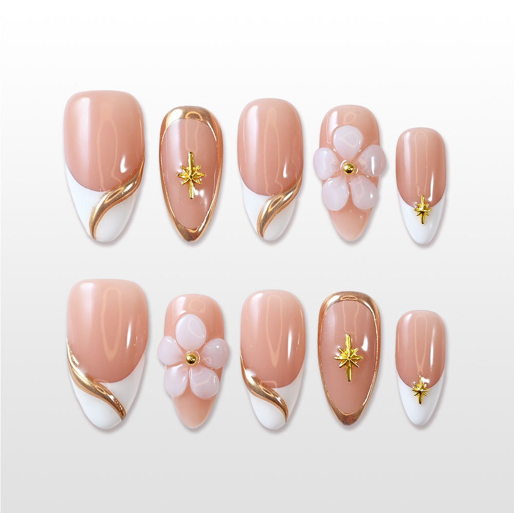 Nude French tip press-on nails with gold swirl accents and 3D flower design