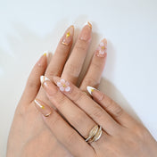 Elegant nude press-on nails with gold star embellishments and white tips