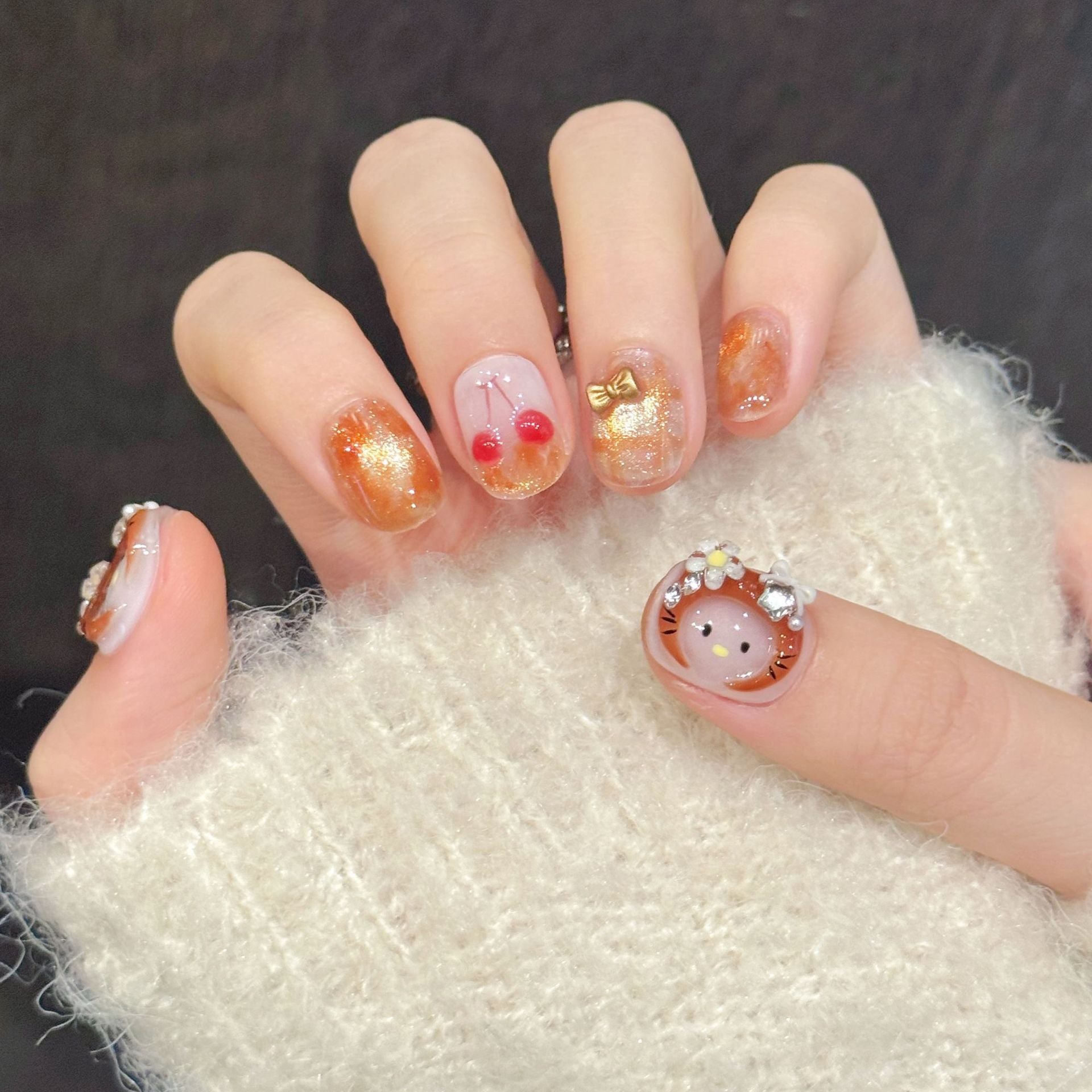 Playful short oval nails with red cherries and golden bow