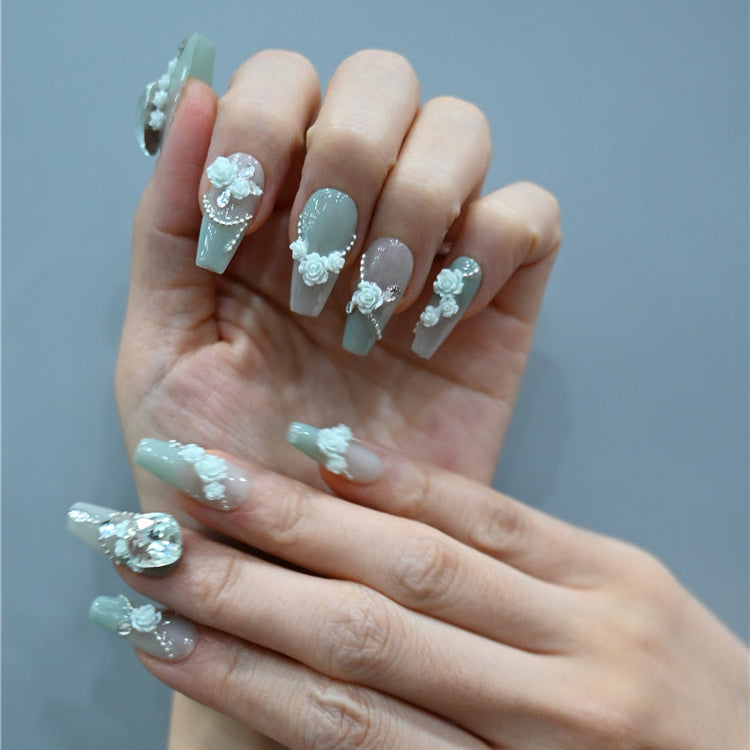 Glam mint green nails with 3D flowers, jewel accents, and chic coffin shape