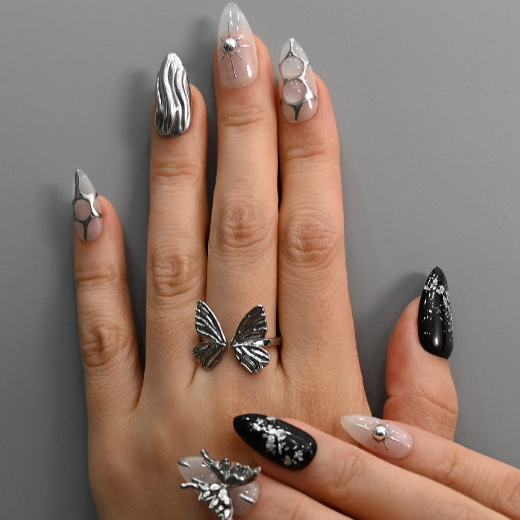 Black and silver 3D press-on nails with starburst gem design and futuristic style