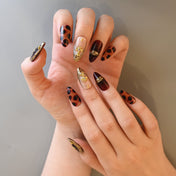 Elegant wine red and leopard press-on nails with gold jewelry-inspired art