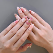 Almond-shaped ombre nails with gold embellishments and blossom designs