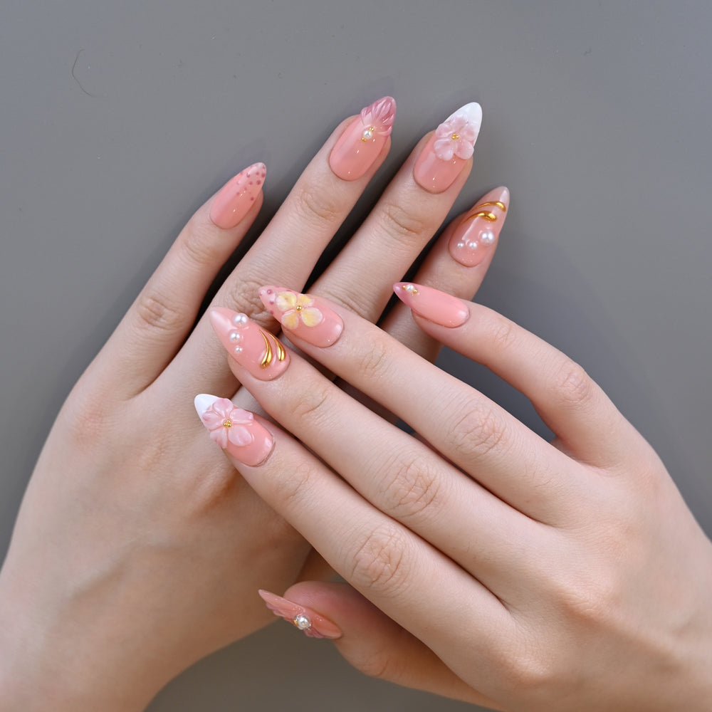 Handmade girly pink press-on nails featuring 3D flowers, pearls, and petal art