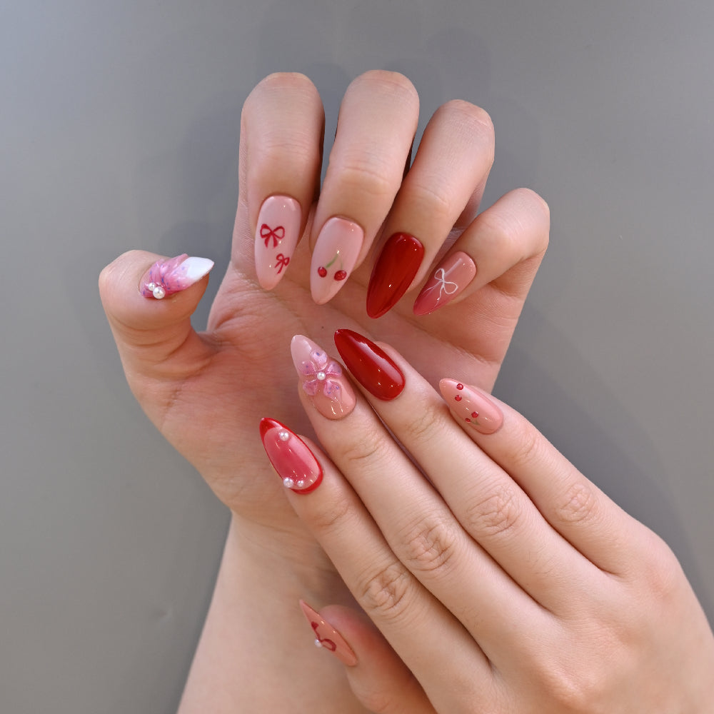 Handmade almond press-on nails with cherries, bows, and floral accents
