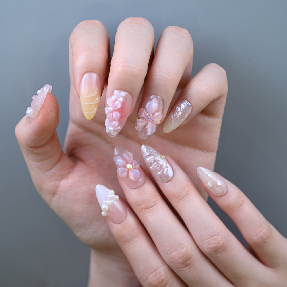 Elegant pastel press-on nails featuring sculpted flowers and shimmering glitter