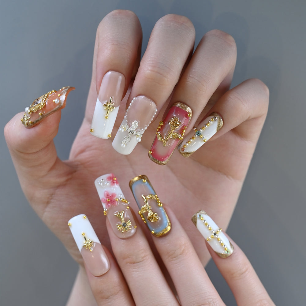 Baroque style press-on nails with gold frame, cross, and gemstone accents