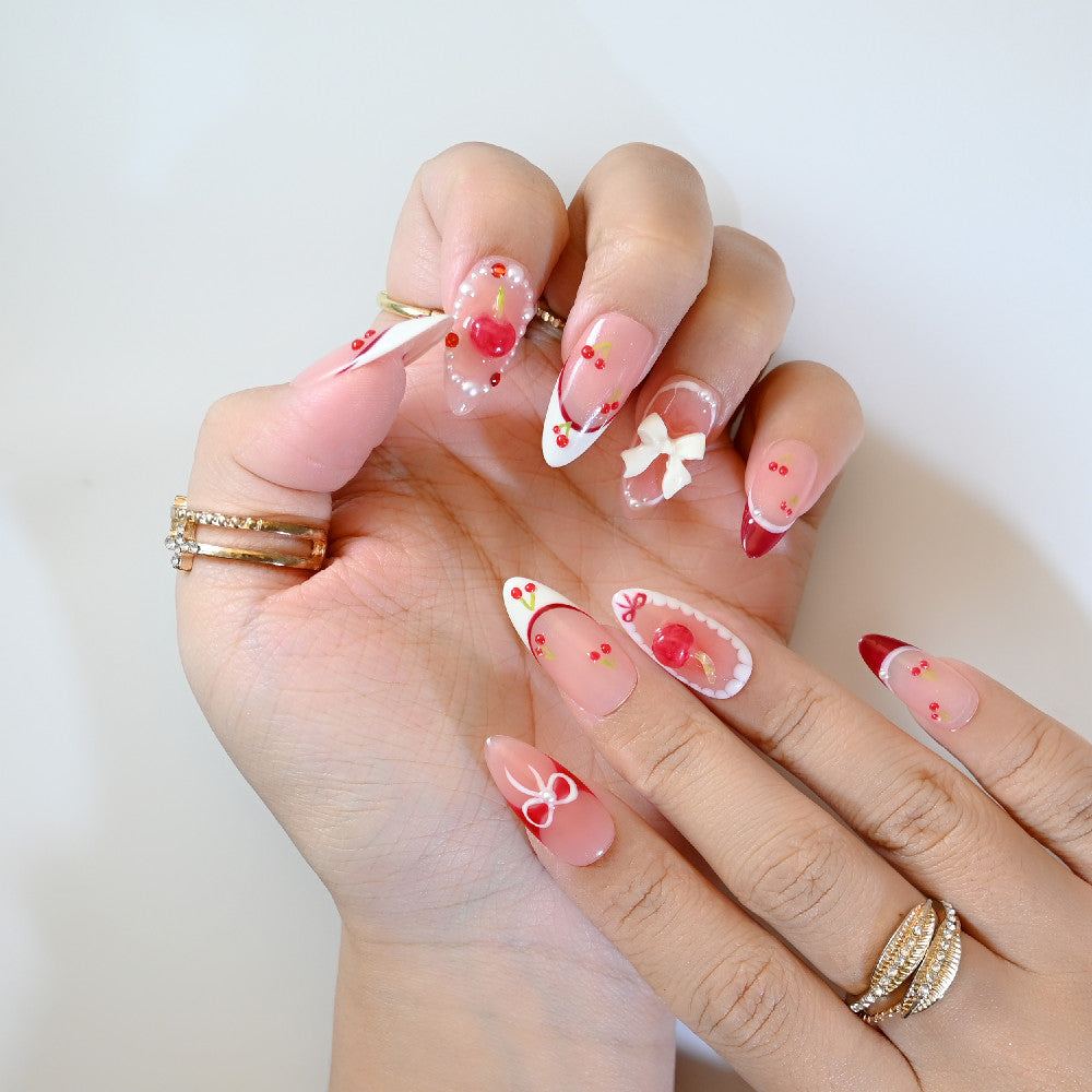 Romantic cherry-themed press-on nails with 3D bow charm and playful details
