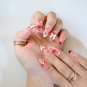 Romantic cherry-themed press-on nails with 3D bow charm and playful details