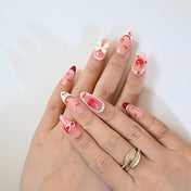 Sweet almond press-on nails with hand-painted cherries, big bow, and red tips
