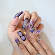 Luxury press-on nails in purple ombre with gold beads and 3D blossoms