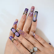 Handmade nude and purple square nails with rhinestones and floral charms