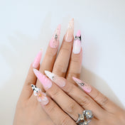 Handmade long stiletto press-on nails in blush pink with polka dots and seashell texture