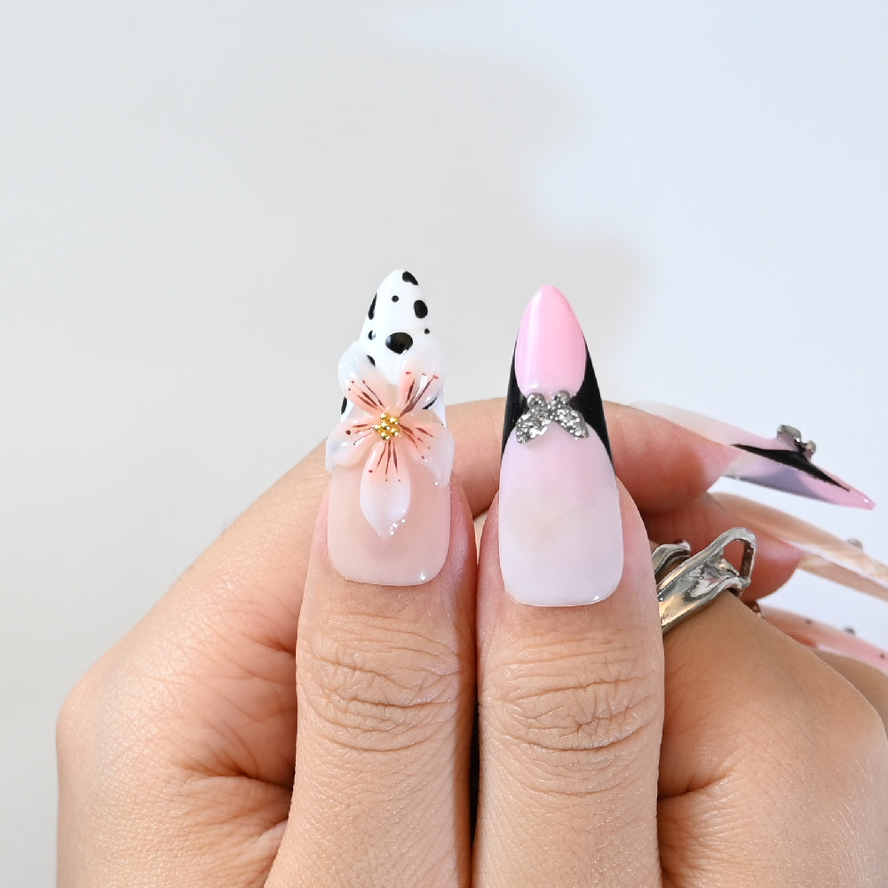 Elegant floral press-on nails with black and white details, crystal rhinestones, and marble tips