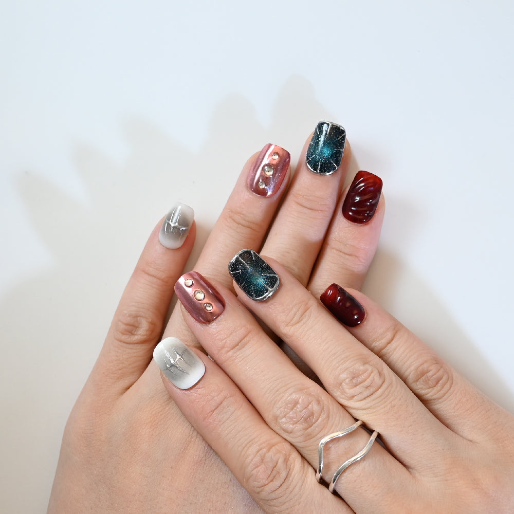 Short square press-on nails featuring galaxy glitter and silver 3D details