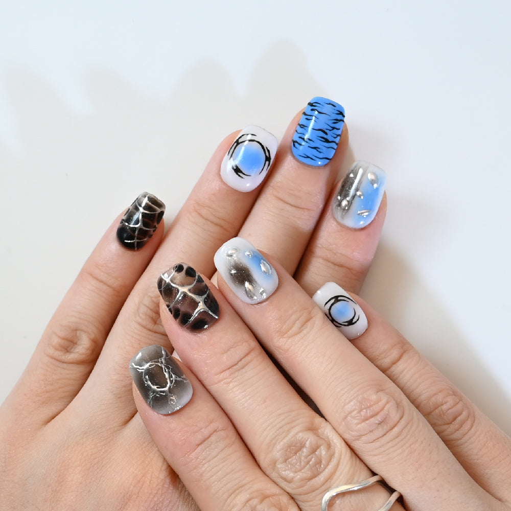 Bold short square nails in blue, black, and silver abstract patterns