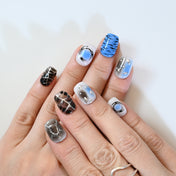 Bold short square nails in blue, black, and silver abstract patterns