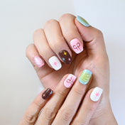 Handmade pastel press-on nails featuring pearl bows, starbursts, and silver frame art