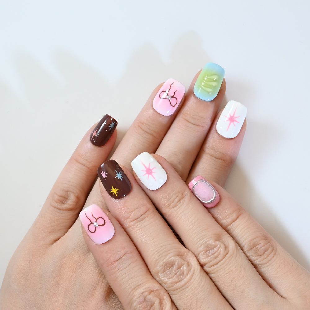 Playful press-on nails with star designs, ribbon bows, and gradient pastel backgrounds