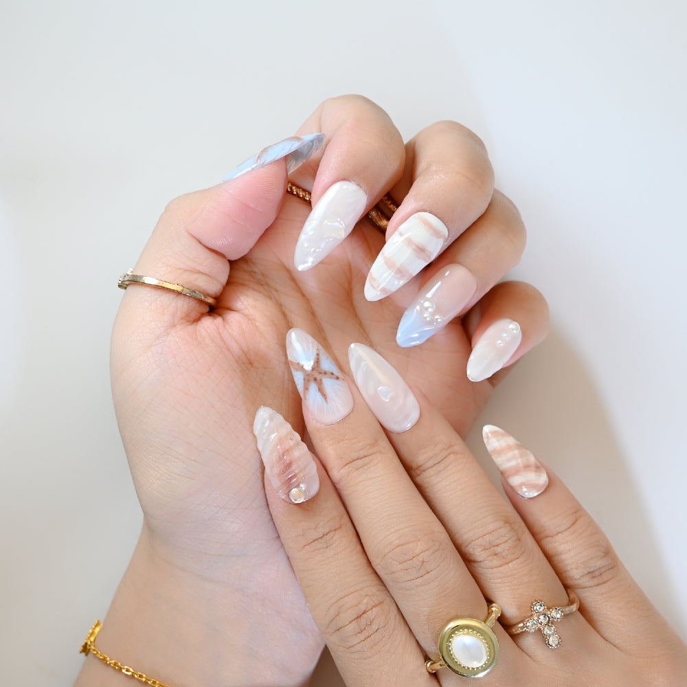 Nautical summer press-on nails with sea star, shell textures, and beach color palette