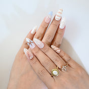 Coastal style press-on nails in sandy beige and blue with starfish and shell designs