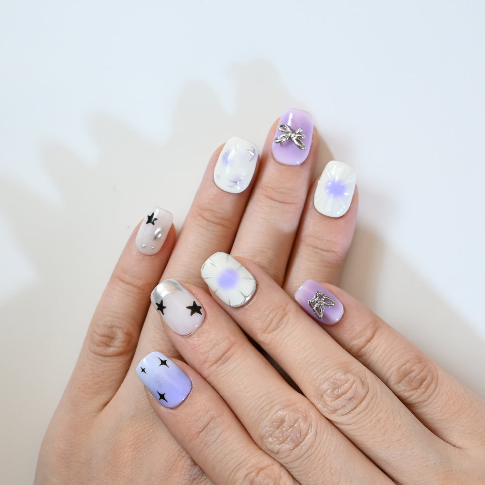 Cute lilac and white press-on nails with celestial theme, 3D charms, and galaxy gradient