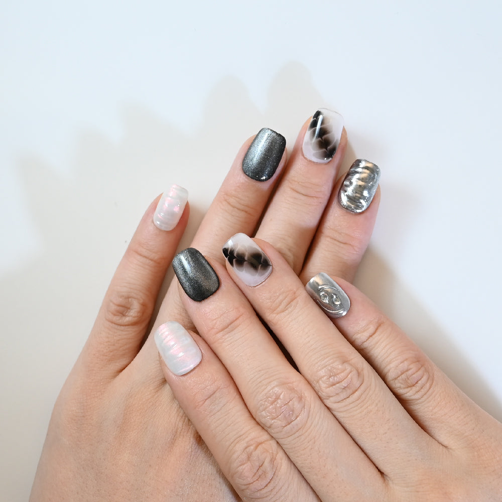 Chic black and gray press-on nails with metallic details and marble smoke effect