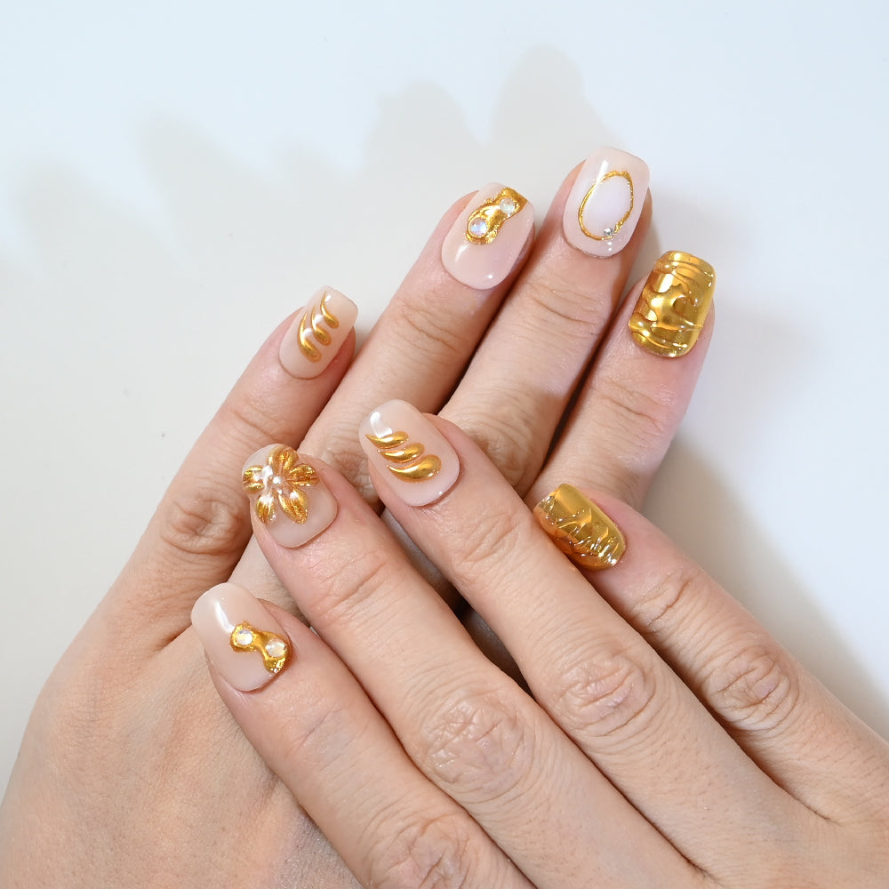 Luxury gold embossed press-on nails with minimalist art on nude base