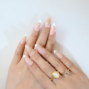 Chic press-on nails with white French tips, gold edges, and gemstone star details